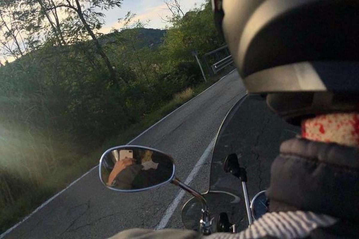 isang taong nakasakay sa motorsiklo na may repleksyon sa side view mirror