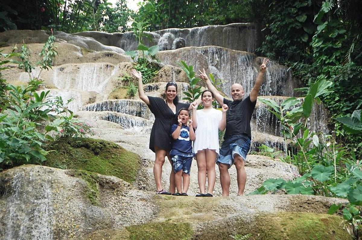 una famiglia in piedi sulle rocce di fronte a una cascata