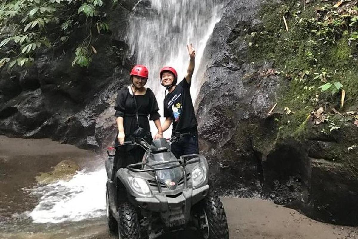 seorang lelaki dan seorang wanita berdiri di hadapan air terjun