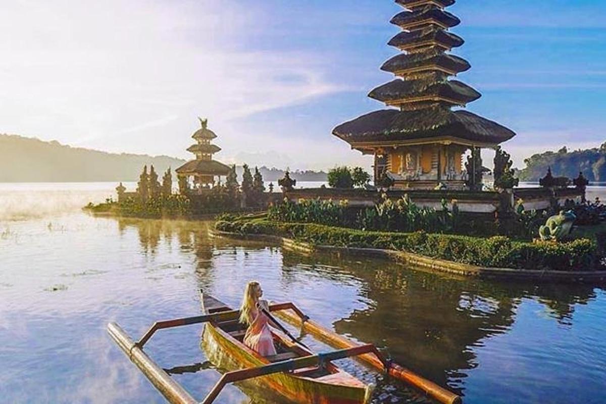 o persoană într-o barcă pe un lac cu o pagodă