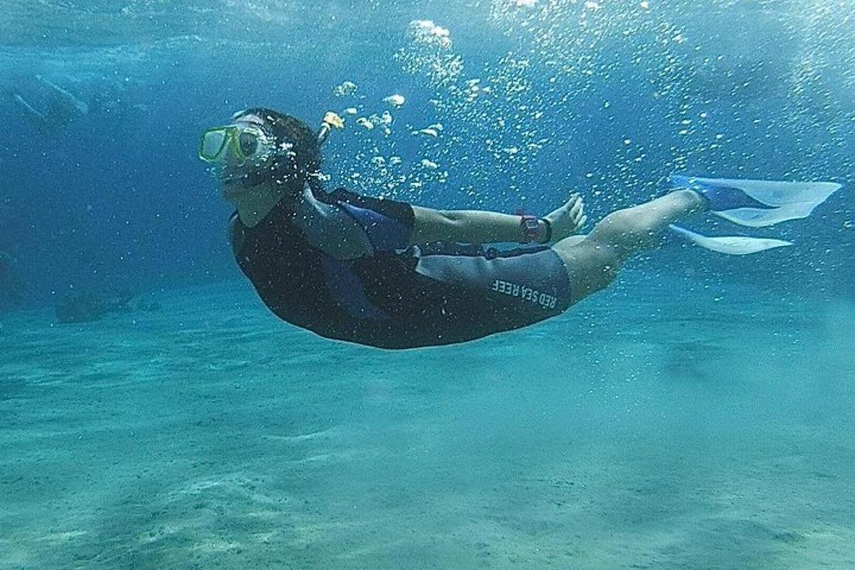 una persona con traje de neopreno y gafas nadando en el agua