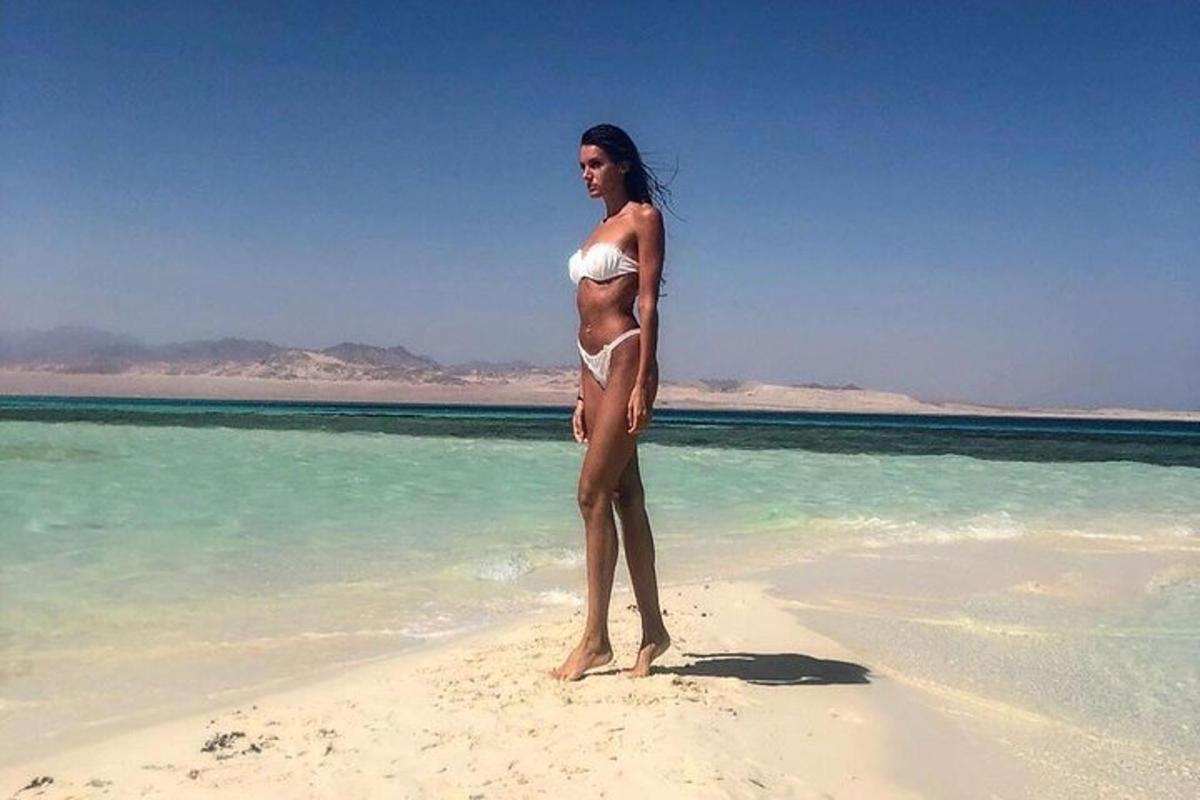kobieta w białym bikini stojąca na plaży