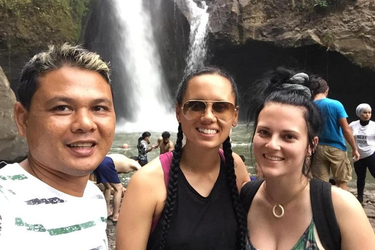 un gruppo di persone in piedi davanti a una cascata