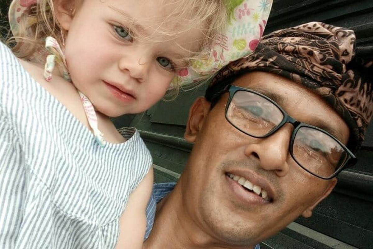 un uomo che tiene una bambina sulle spalle