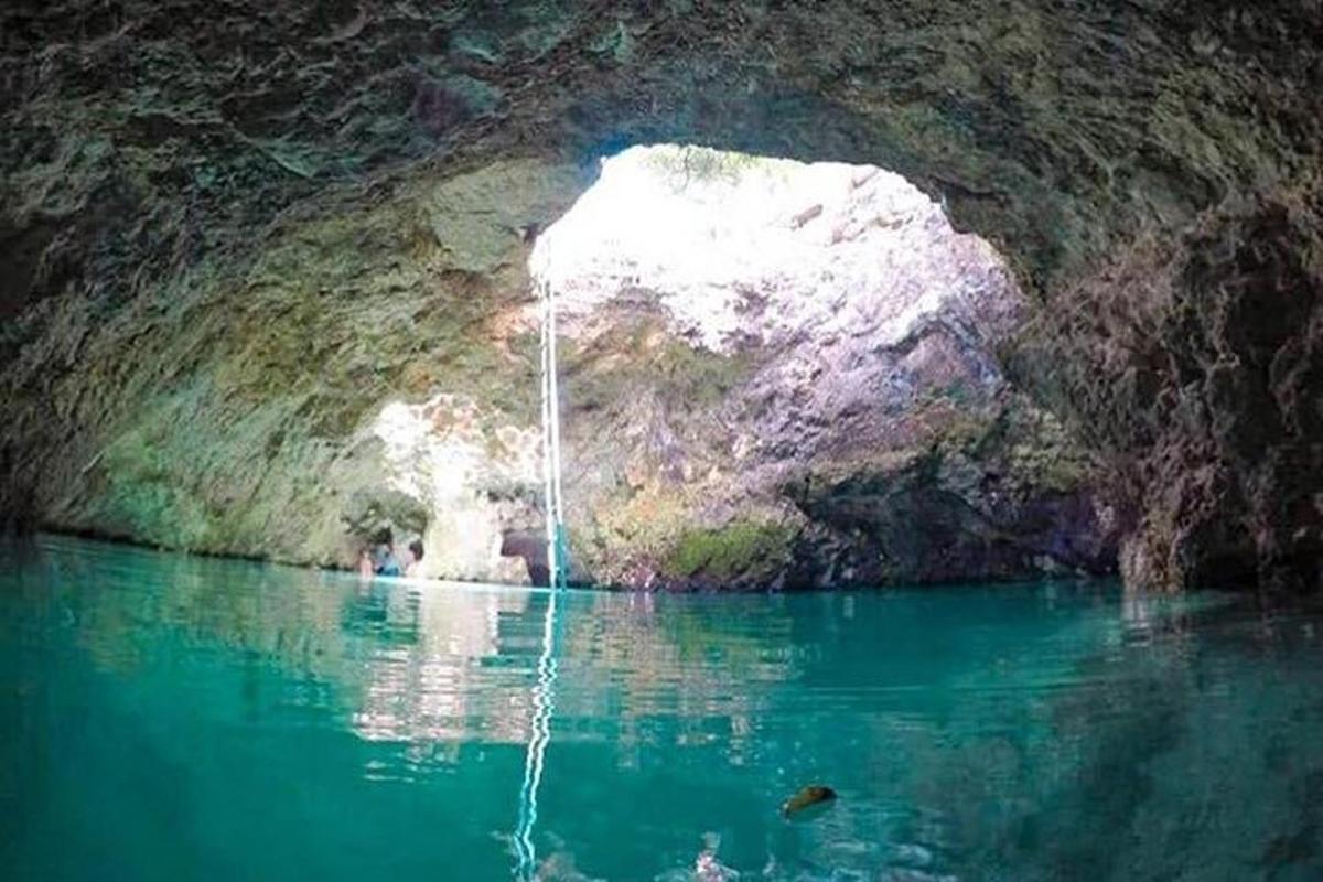 un bassal d'aigua en una cova amb una cascada