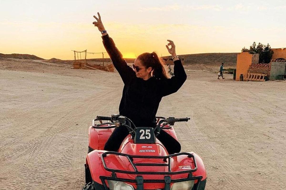 a woman sitting on a motorcycle in the desert