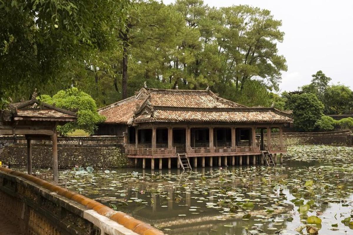 a building in a pond with lily pads in it