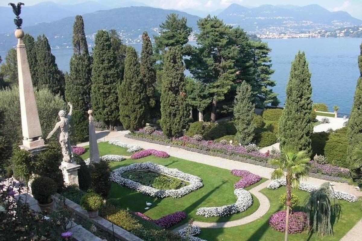 a garden with a statue and flowers in the grass
