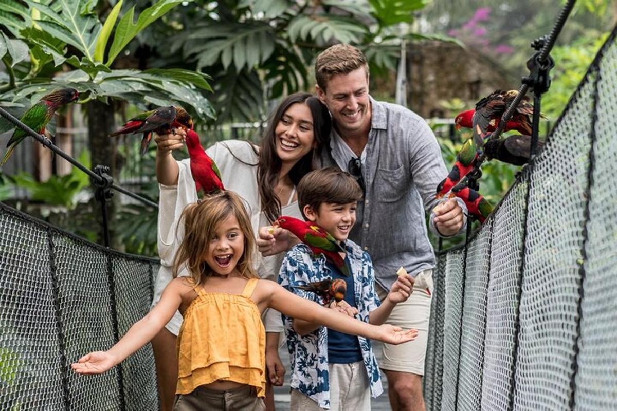 a family posing for a picture at the zoo with birds