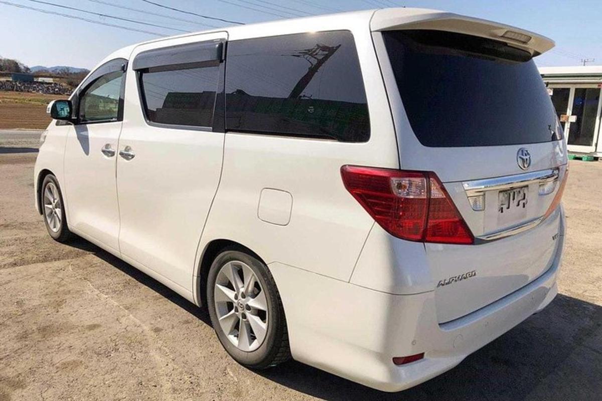 en hvid minivan parkeret på en parkeringsplads
