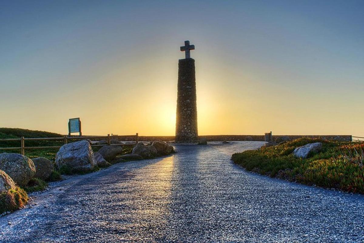 una croce alla fine di una strada con un faro