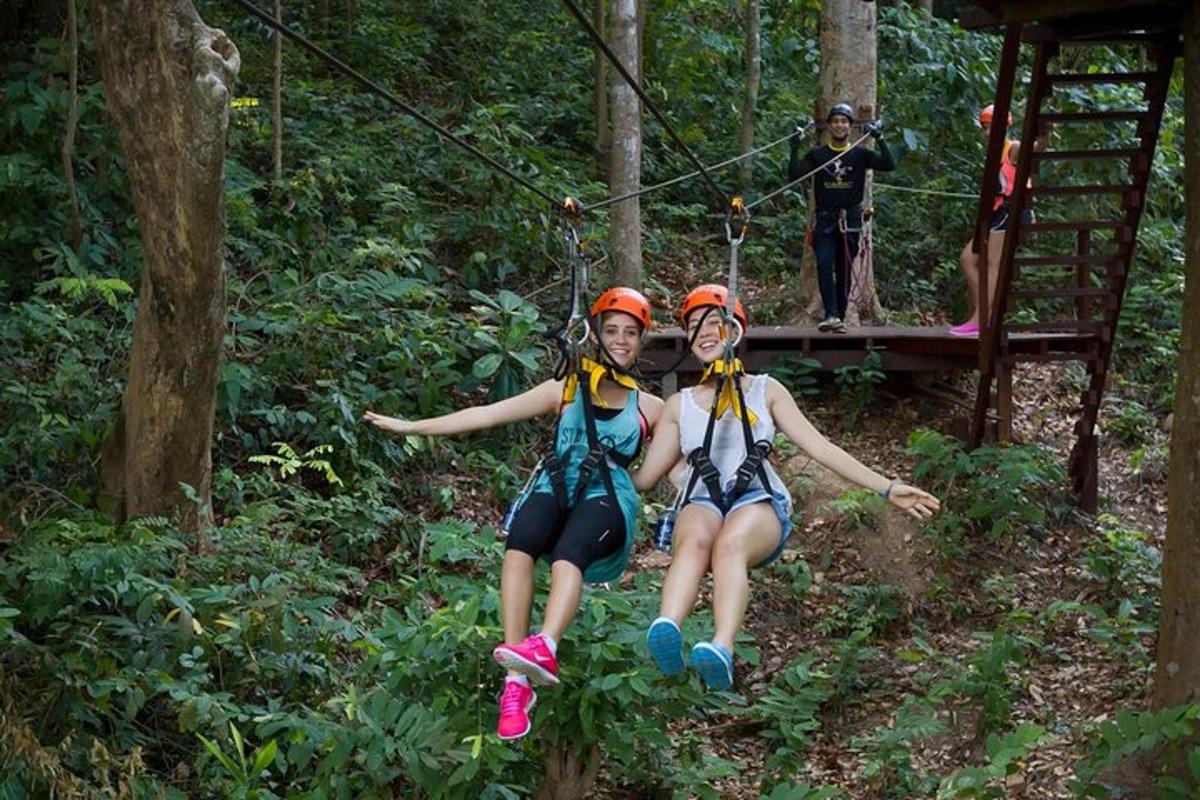 two people on a zip line in the forest