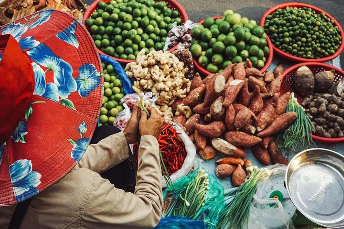 seorang wanita berdiri di hadapan meja buah-buahan dan sayur-sayuran