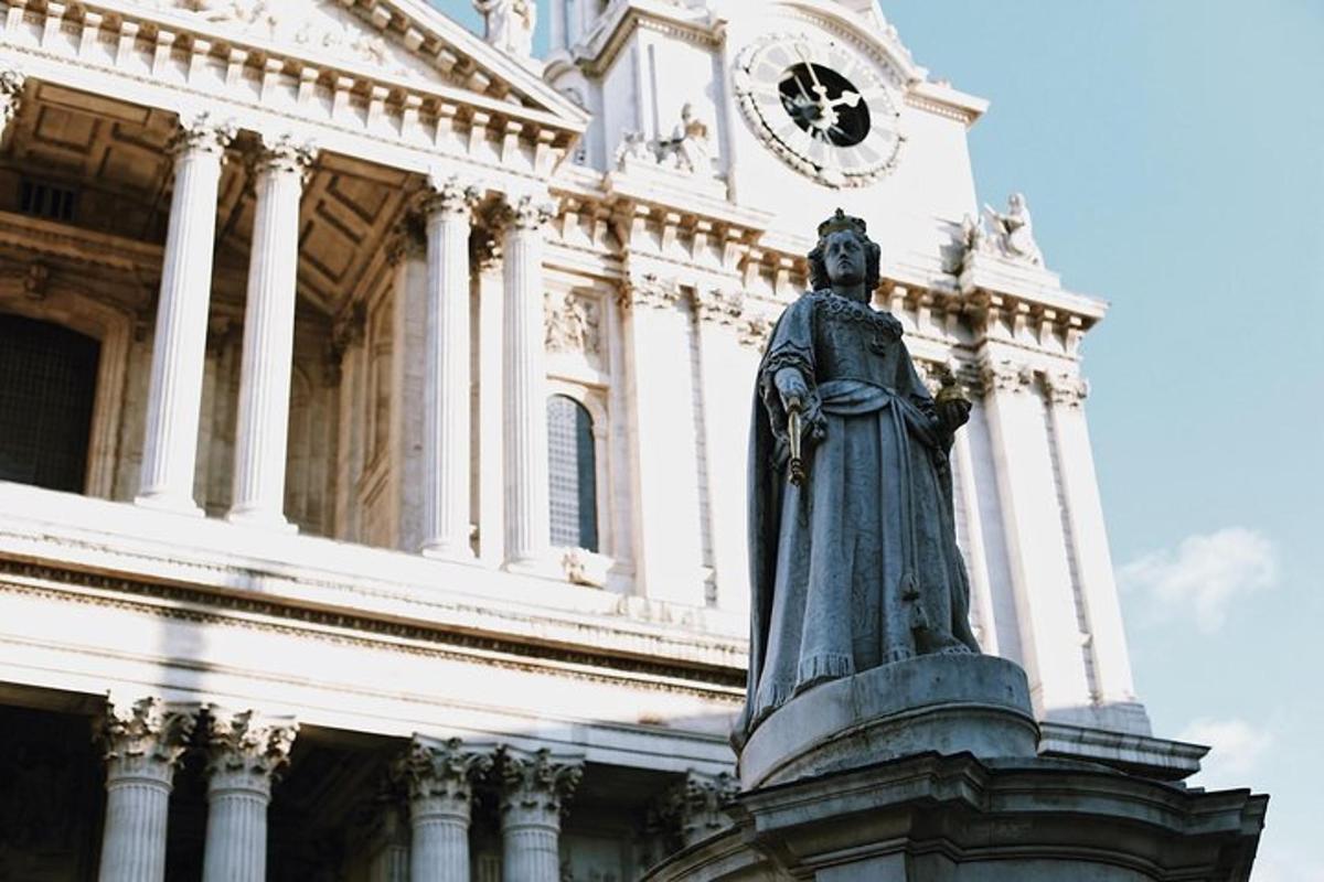 una statua di fronte a un edificio con una torre dell'orologio