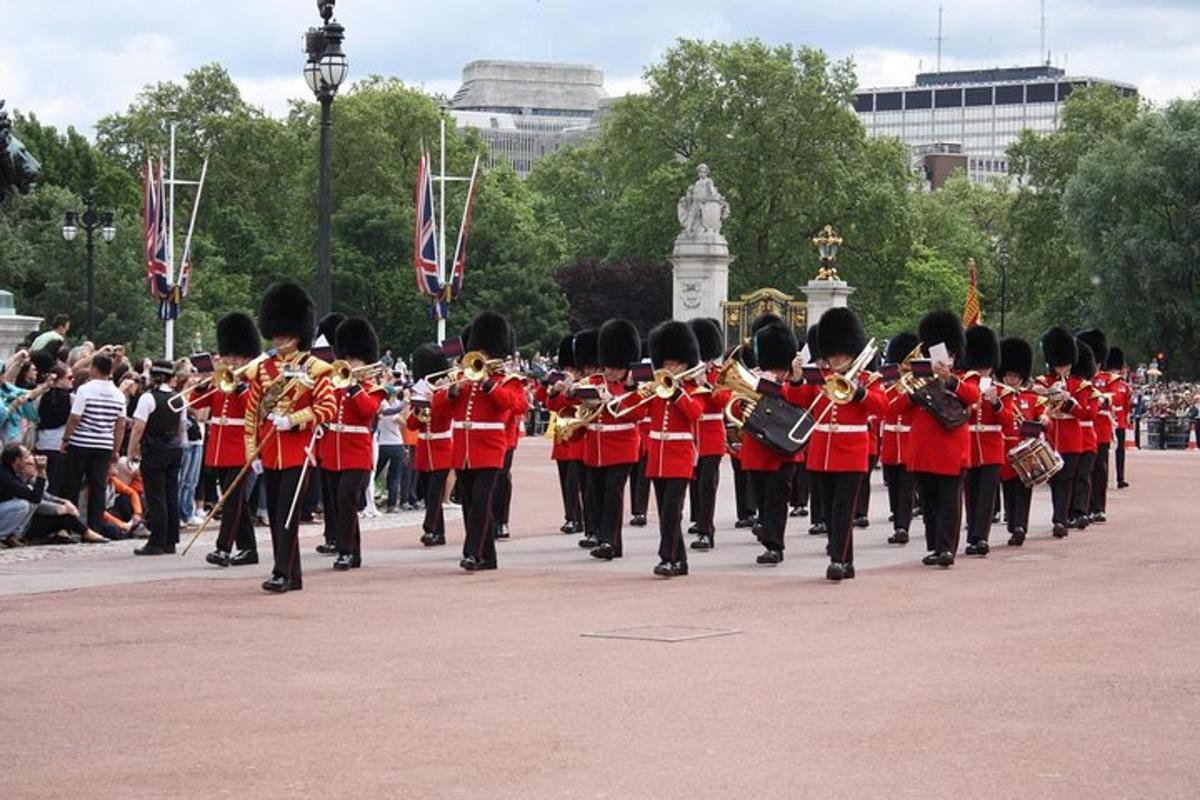 una banda musicale in uniforme rossa che cammina lungo la strada