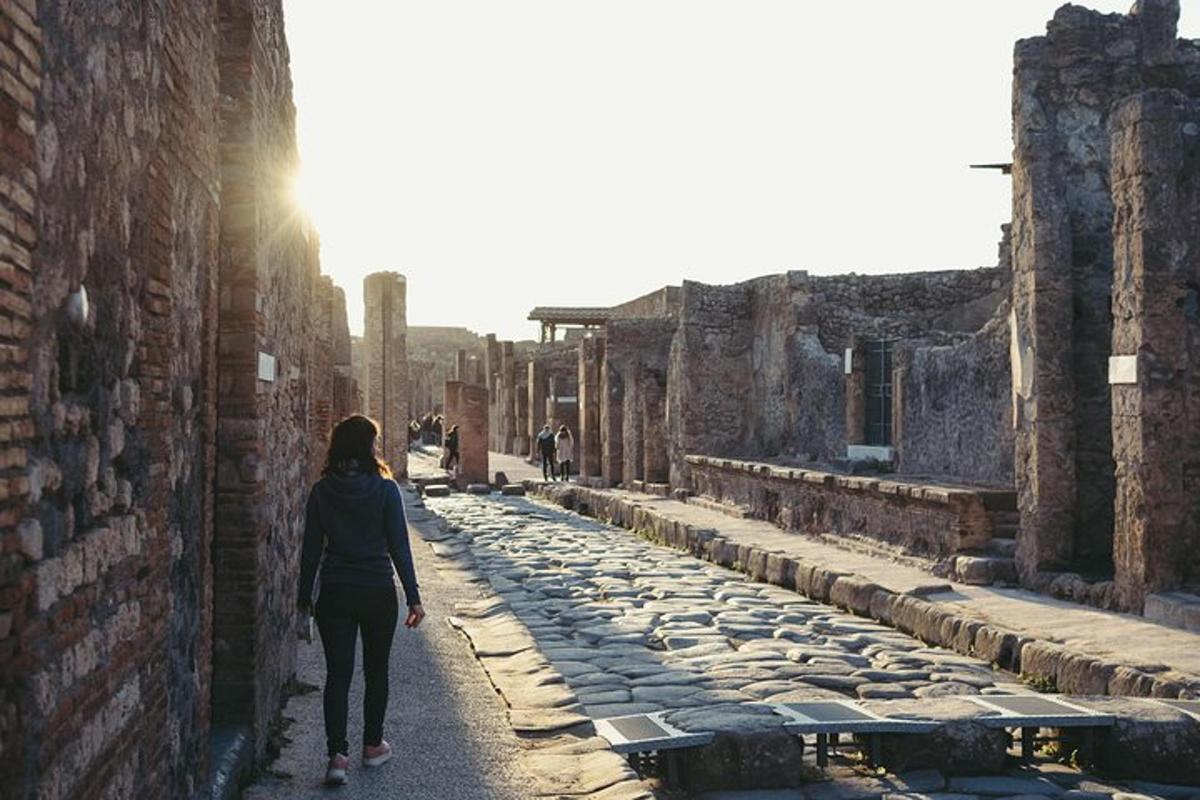 μια γυναίκα περπατάει σε ένα σοκάκι μέσα στα ερείπια