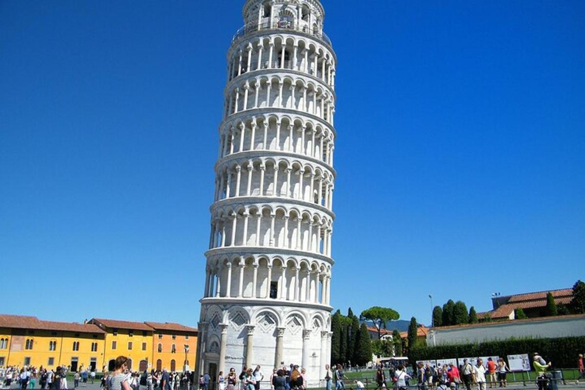 a tall leaning tower with people standing around it