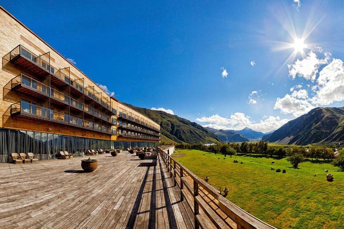 Un edificio con vistas a un campo y a las montañas.