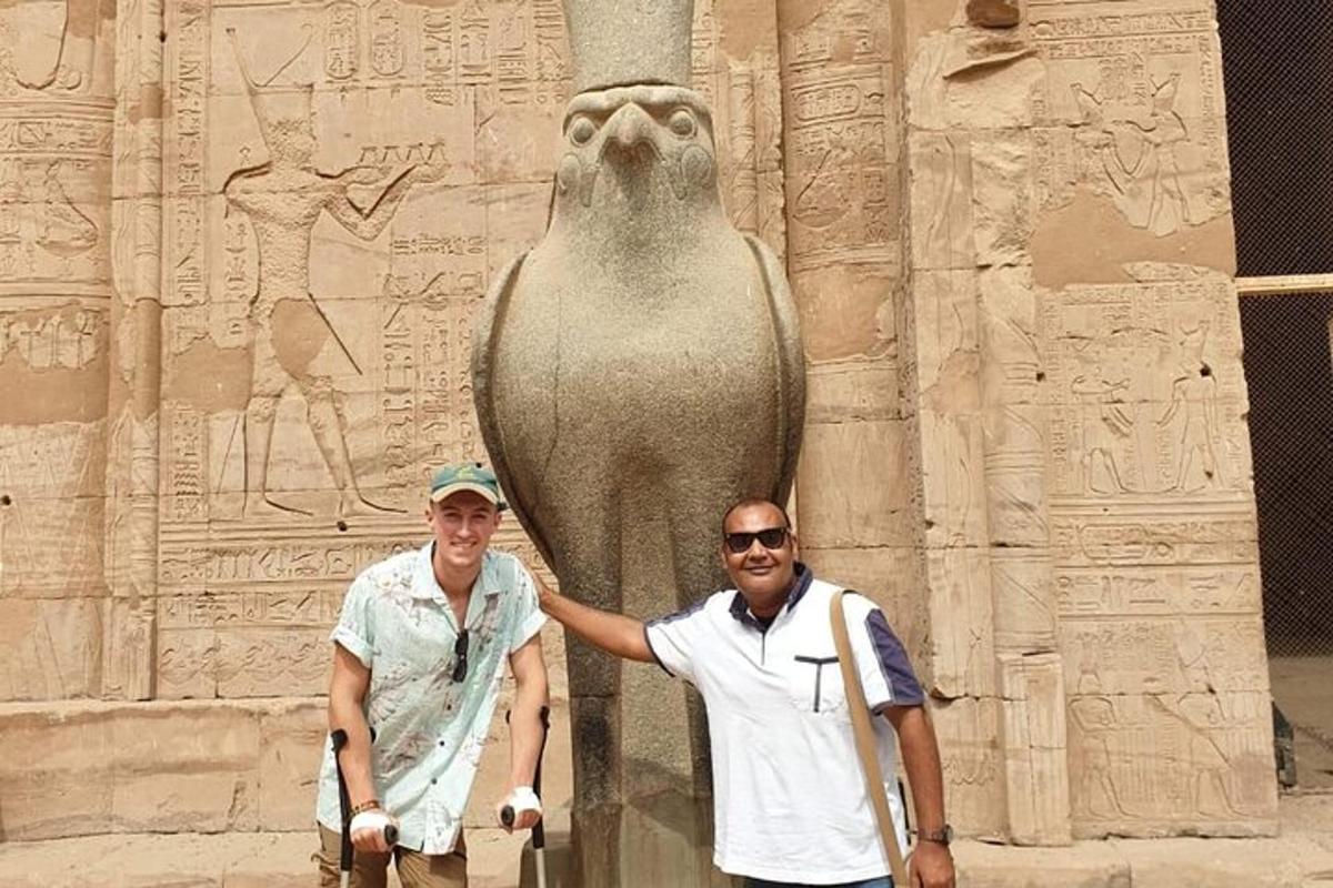 two men are standing in front of a statue