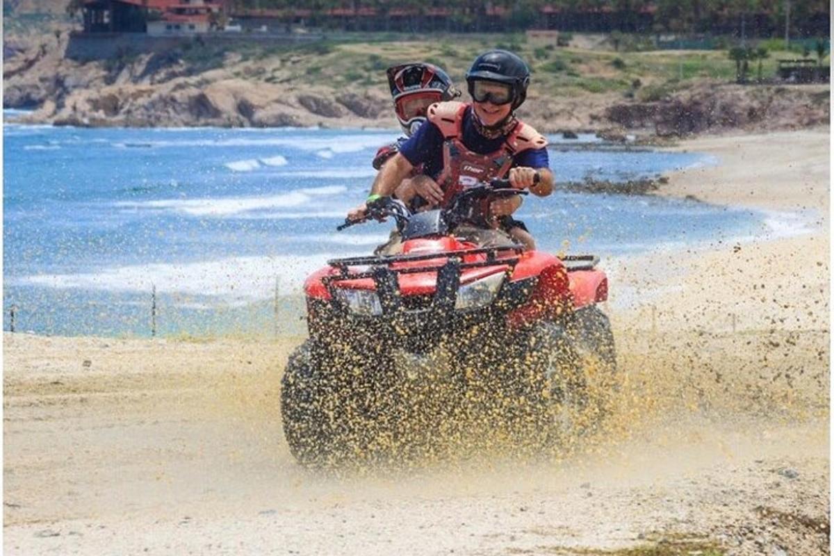 due persone che viaggiano sul retro di un quad sulla spiaggia