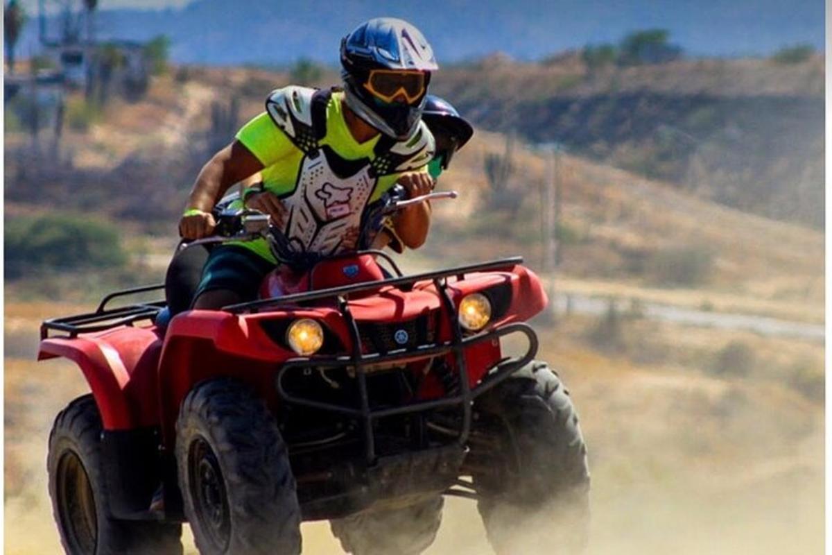 una persona che guida un quad nello sporco