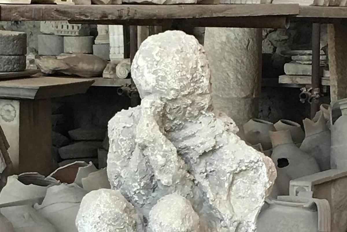 una statua di una persona seduta su un mucchio di rocce