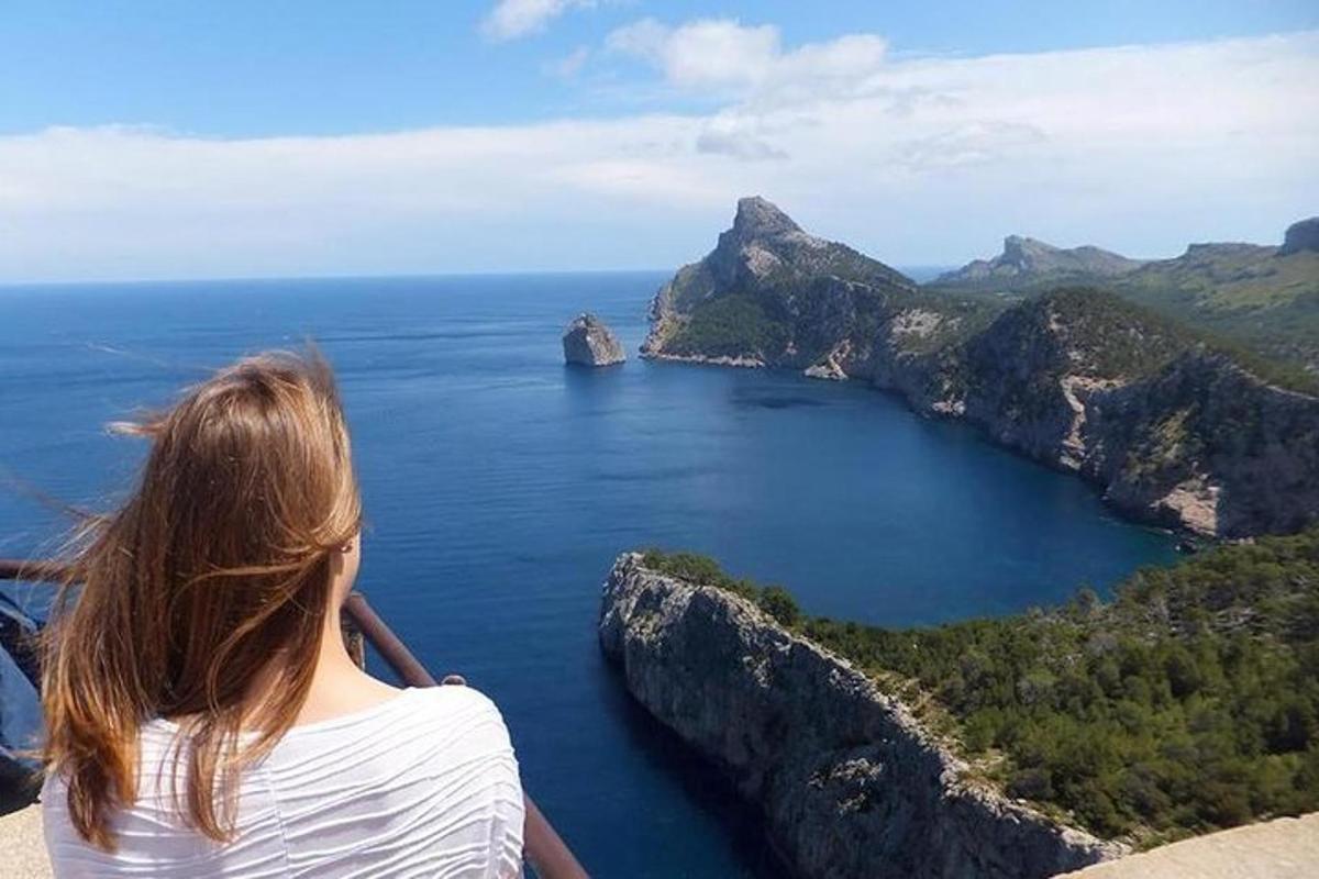 o femeie care stă pe o stâncă și privește oceanul