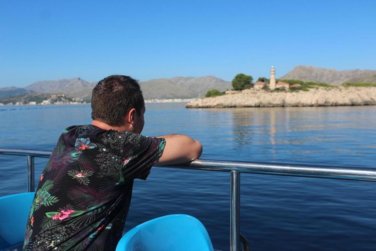 un uomo in piedi su una barca che guarda un faro