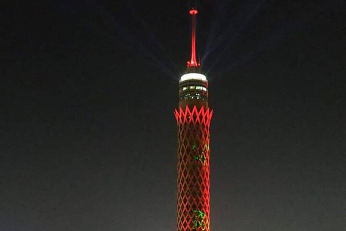 uma torre alta iluminada com luzes vermelhas e verdes