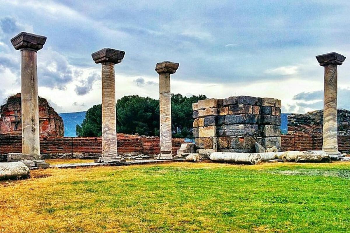 an ancient building with columns in a field