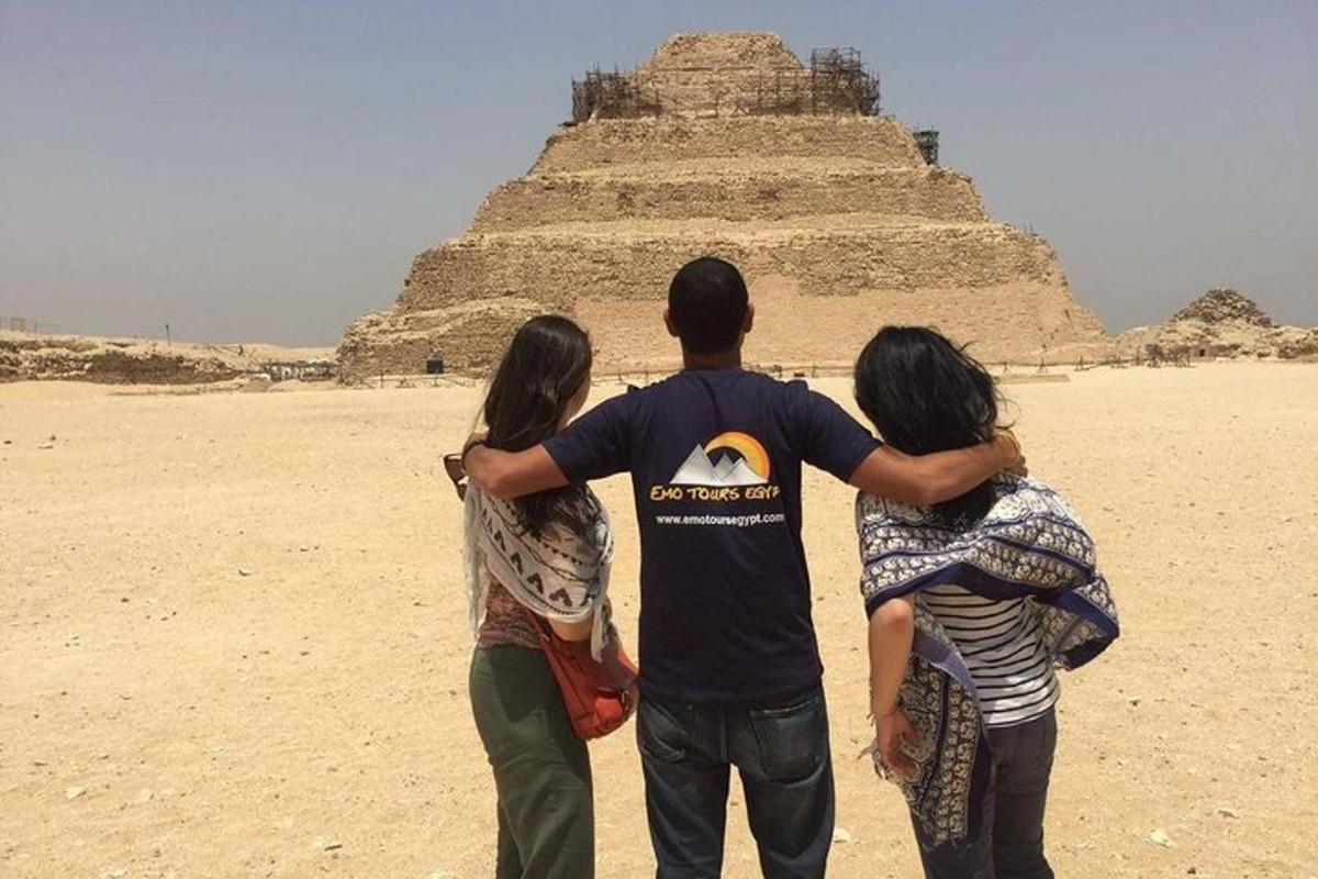 skupina lidí stojící před pyramidou