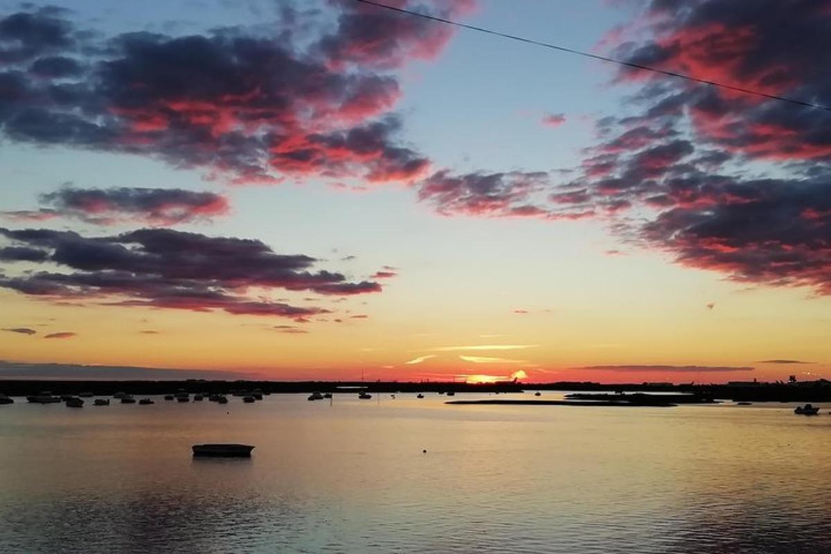 un tramonto su uno specchio d'acqua con barche