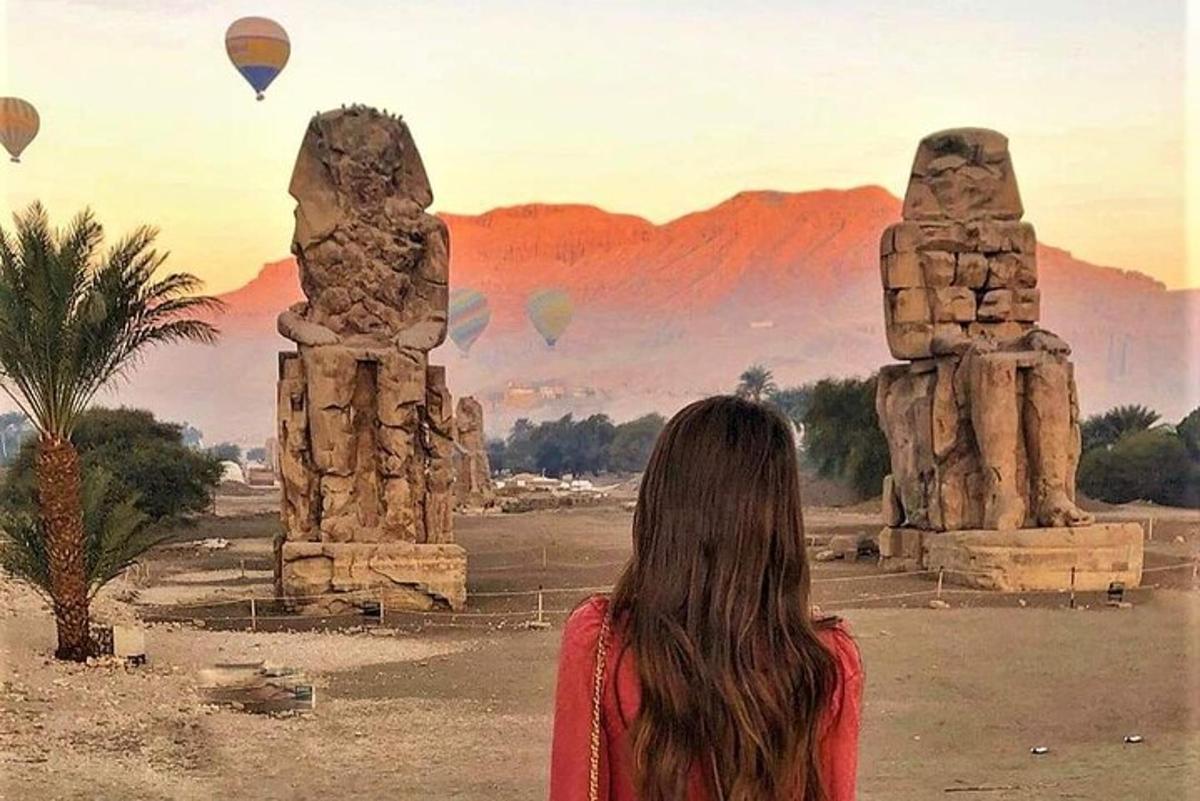seorang wanita sedang melihat belon udara panas di padang pasir