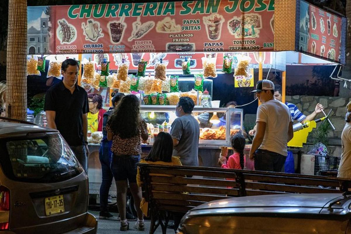 isang grupo ng mga tao na nakatayo sa harap ng isang food stand