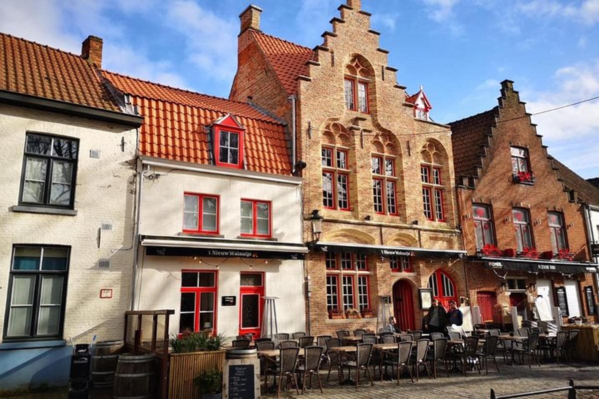 a group of buildings with tables and chairs on a street
