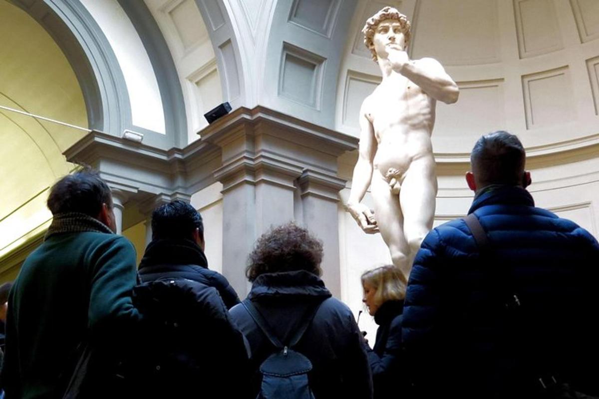 a group of people looking at a statue in a museum