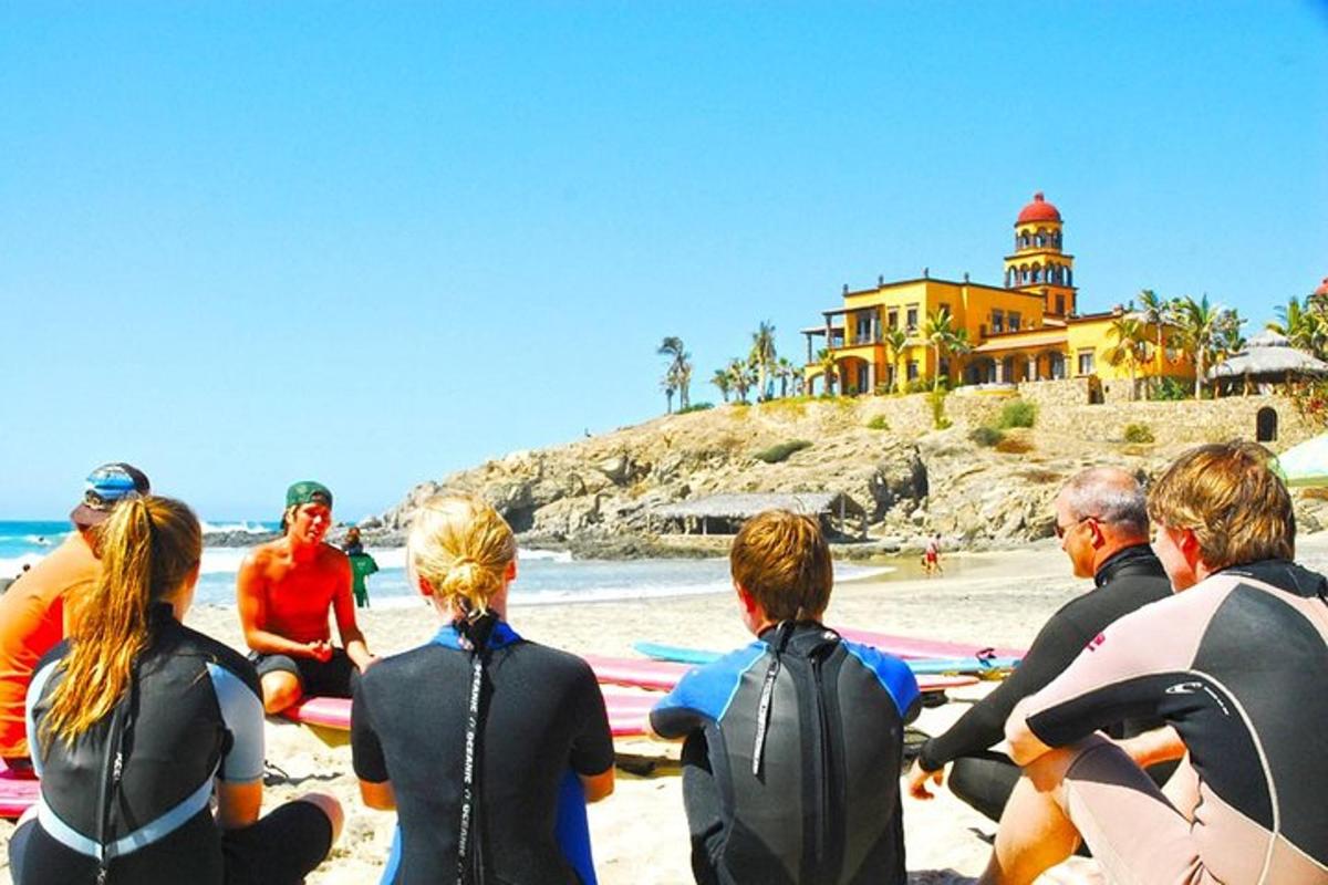 Un grupo de personas sentadas en una playa con tablas de surf