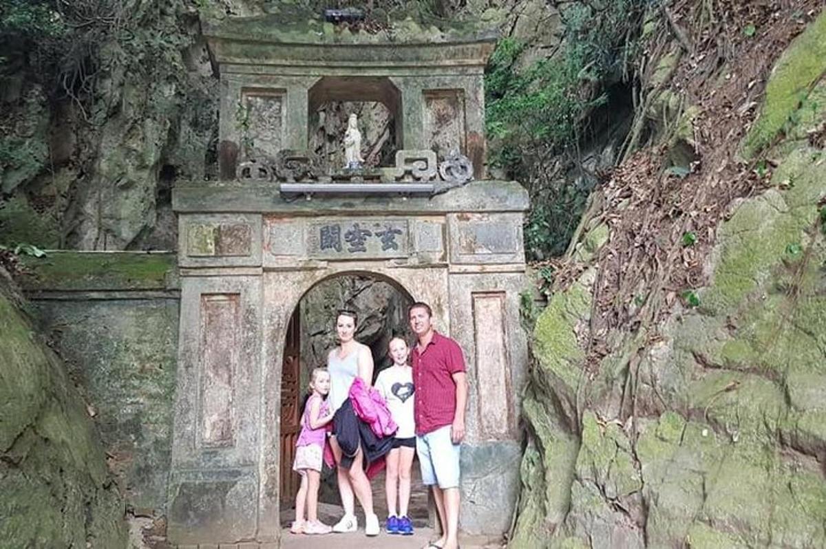 una famiglia posa davanti a un arco in una struttura in pietra
