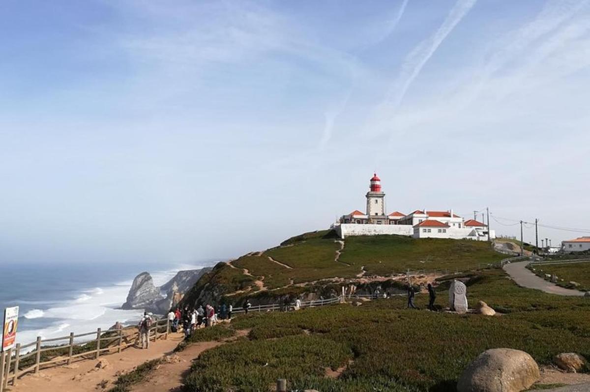 un faro in cima a una collina vicino all'oceano