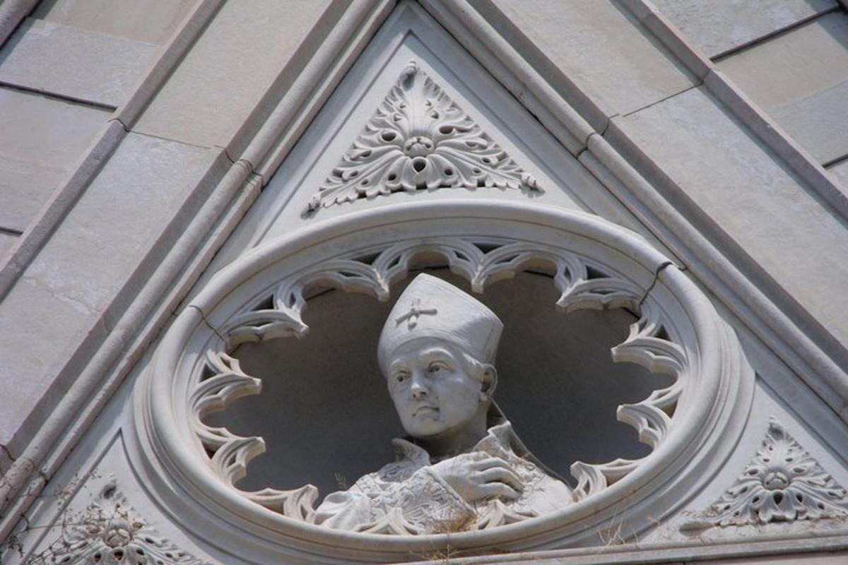 Una estatua de una mujer con sombrero en un edificio.