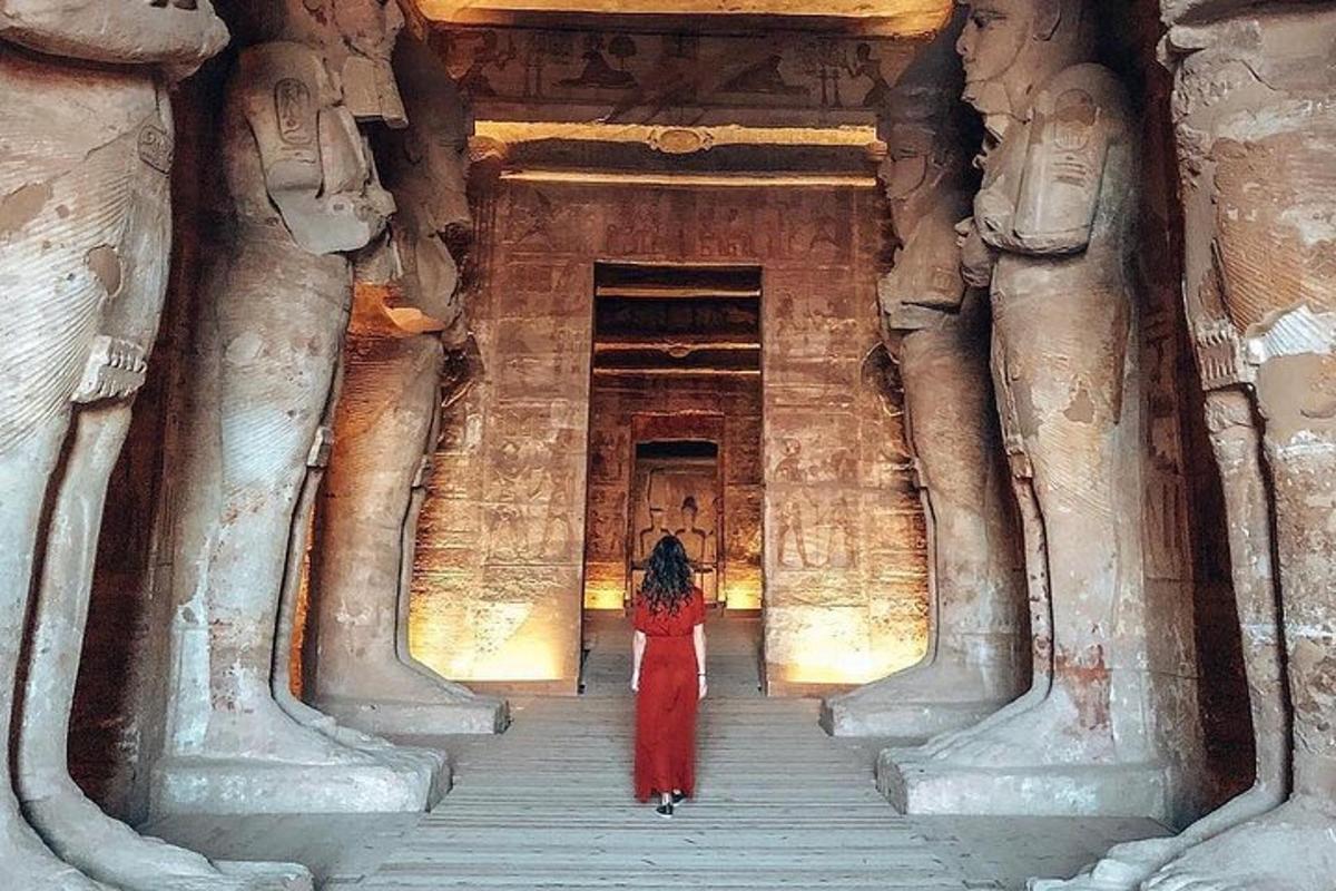 a woman in a red dress standing in a temple