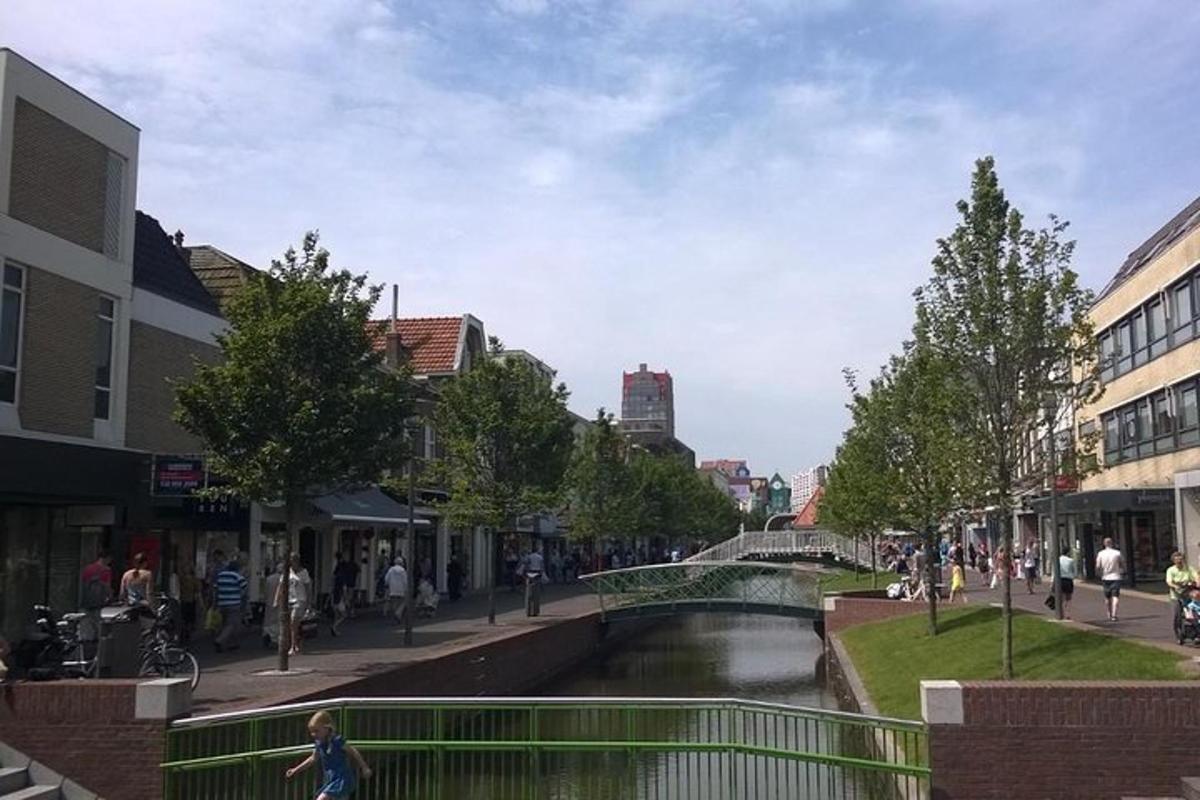 una strada cittadina con un canale e persone che camminano sul marciapiede