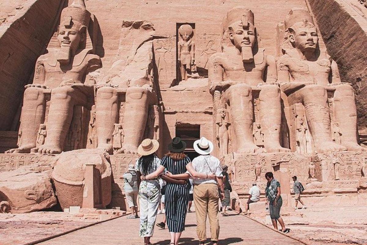 a group of people walking in front of a statue