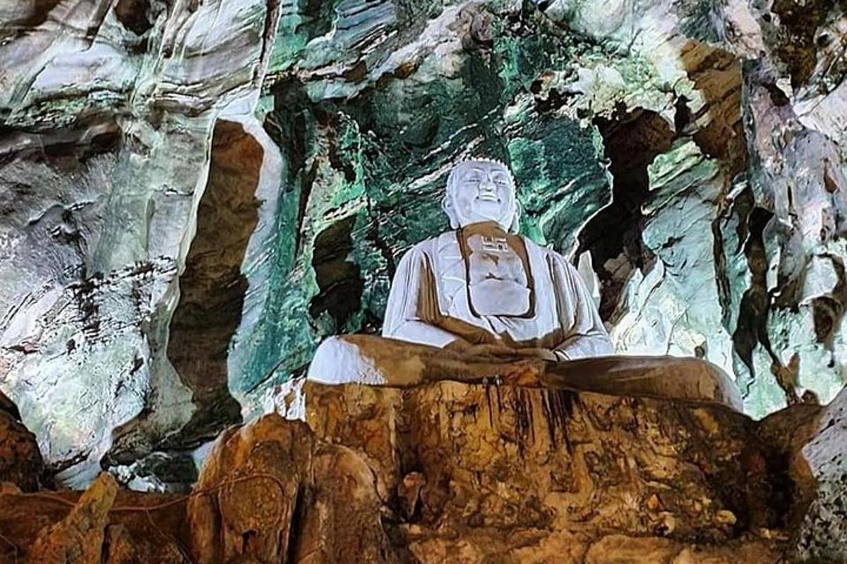 una estatua sentada sobre una roca en una cueva