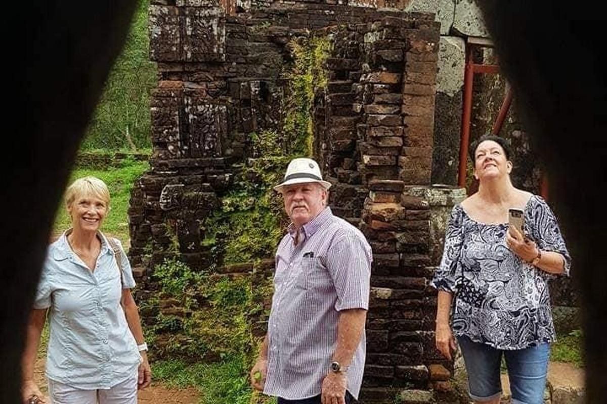 un gruppo di tre persone in piedi davanti a un edificio