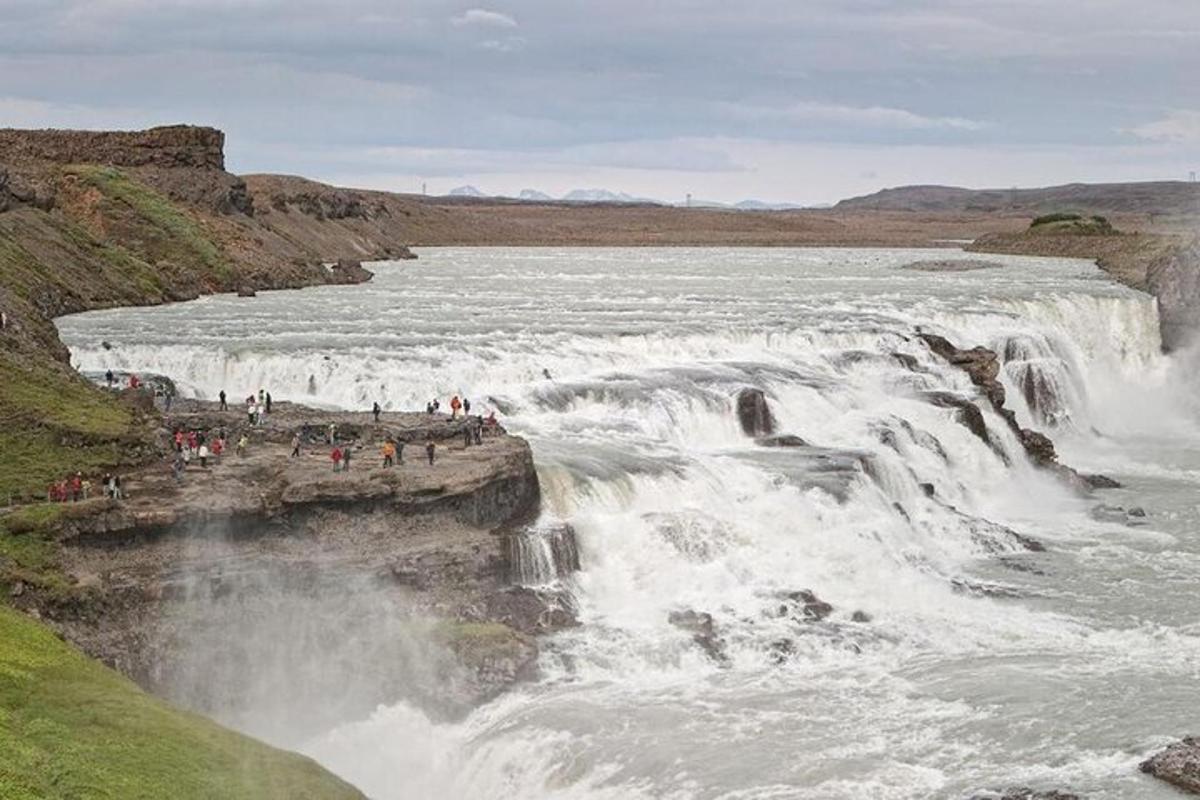 mensen die aan de rand van een waterval staan