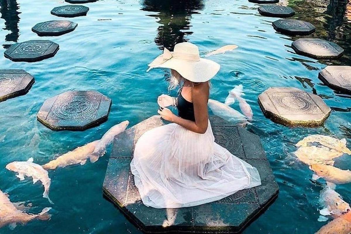 Una mujer con un vestido blanco sentada en el agua.