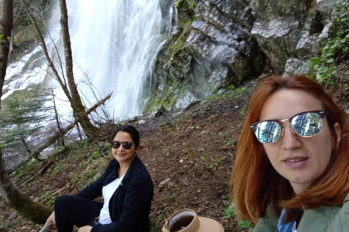 Dos mujeres paradas frente a una cascada