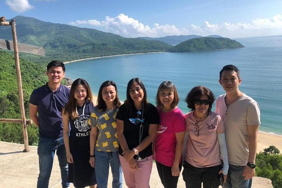 un grup de persones posant per a una foto davant de l'oceà