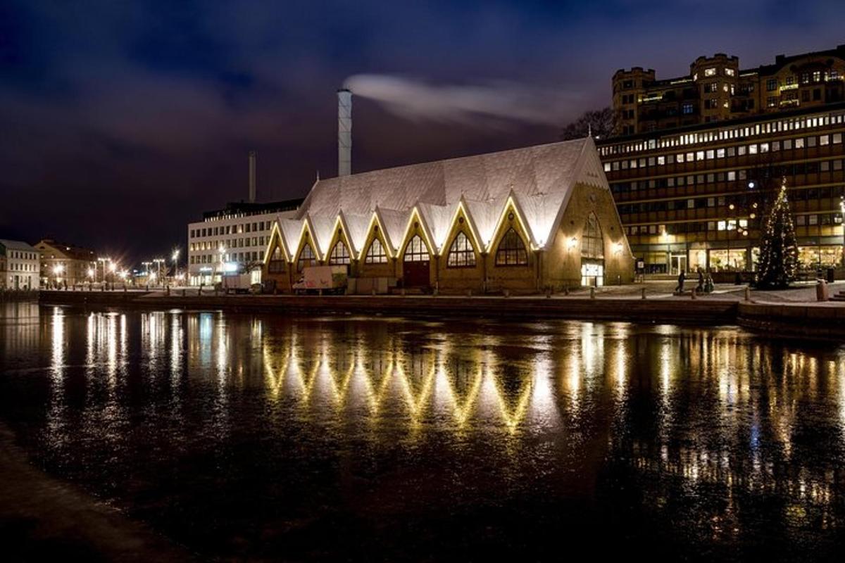 a large building with lights on the water at night